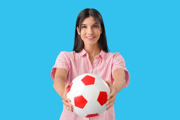 若いです女性とともにサッカーボール上の青の背景 — ストック写真