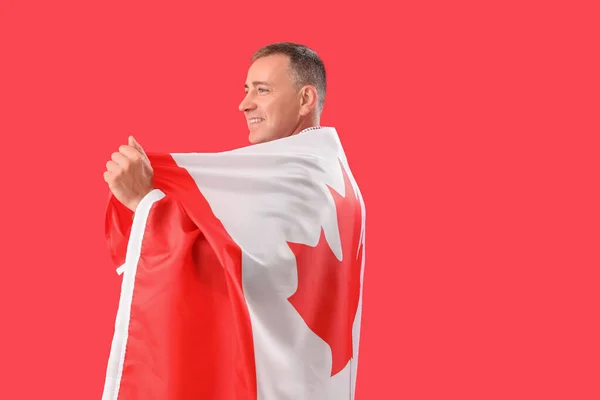 Kırmızı Arka Planda Kanada Bayrağı Taşıyan Olgun Bir Adam — Stok fotoğraf