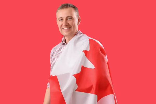 Kırmızı Arka Planda Kanada Bayrağı Taşıyan Olgun Bir Adam — Stok fotoğraf