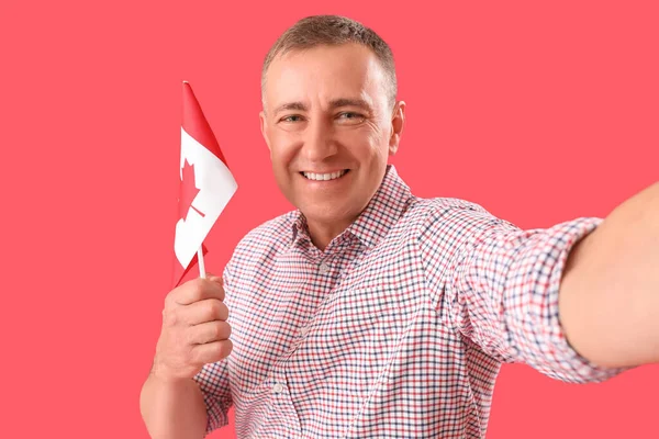 Dojrzały Mężczyzna Flagą Kanady Robi Selfie Czerwonym Tle Zbliżenie — Zdjęcie stockowe