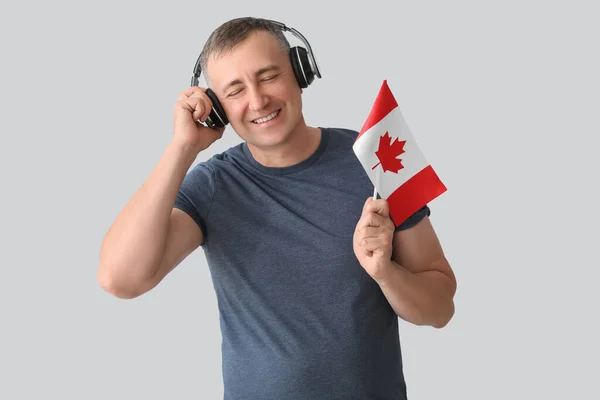 Dojrzały Mężczyzna Słuchawkach Flagą Kanady Jasnym Tle — Zdjęcie stockowe