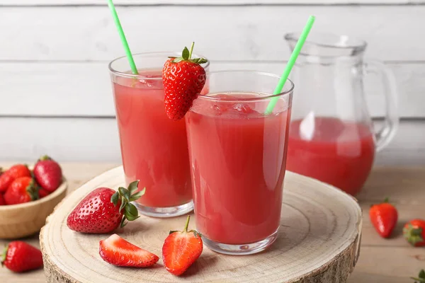 木桌上的酒壶和一杯美味的草莓汁 — 图库照片