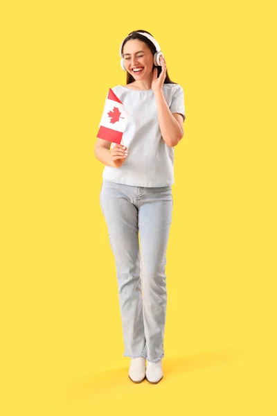 Νεαρή Γυναίκα Ακουστικά Σημαία Καναδά Κίτρινο Φόντο — Φωτογραφία Αρχείου