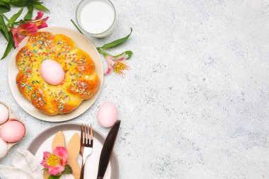 Lezzetli İtalyan Paskalya ekmeği, yumurta, bir bardak süt ve çiçekli masa ayarı