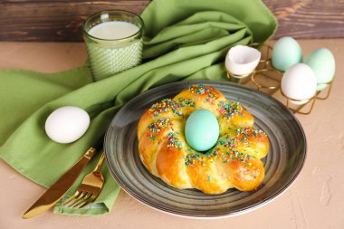 Lezzetli İtalyan Paskalya ekmeği, yumurta ve bir bardak sütle dolu bir tabak.
