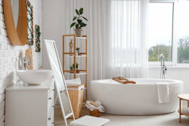 Küvetli, aynalı ve lavabolu bir banyo.