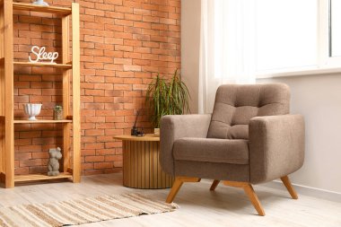 Oturma odası, rahat kahverengi koltuk, ahşap sehpa ve raf ünitesi.