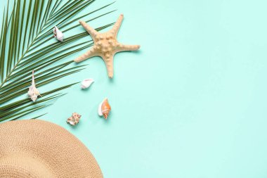 Palmiye yaprağı, şapka ve deniz kabuğu renginde kompozisyon