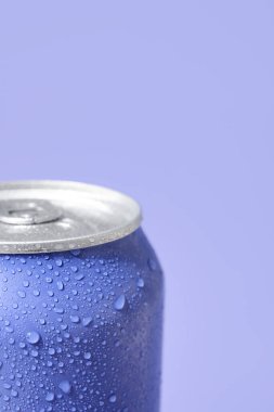 Leylak arka planında su damlaları olan bir kutu taze soda, yakın plan.