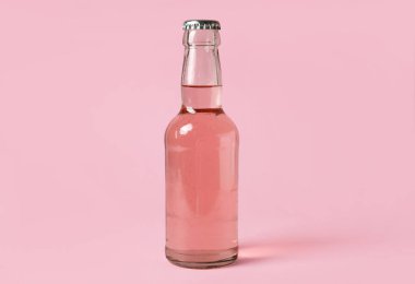 Pembe arka planda bir şişe taze soda.