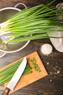 Ahşap zemin üzerinde taze yeşil soğan olan tahta.