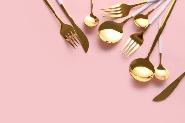 Pembe arka planda şık çatal bıçak takımı