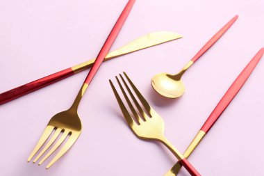 Pembe arka planda şık çatal bıçak takımı