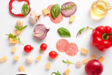 Beyaz arkaplanda pizza hazırlamak için gerekli malzemeler