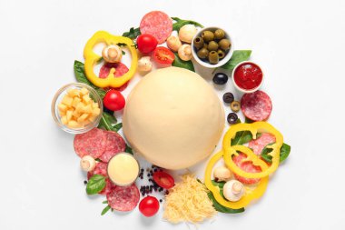 Beyaz arka planda pizza hazırlamak için ham hamur ve malzemeler