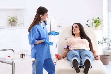 Kadın kan bağışçısı klinikteki hemşireyle konuşuyor.