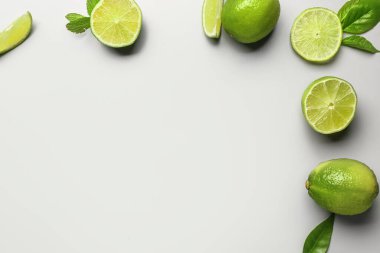 Naneli taze limonlardan yapılmış çerçeve ve gri arka planda yapraklar