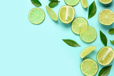 Mavi arka planda yaprakları olan taze limon dilimleri