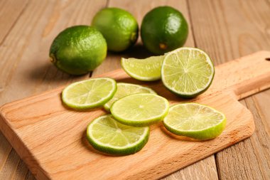 Ahşap zemin üzerinde taze limon dilimleri olan tahta.