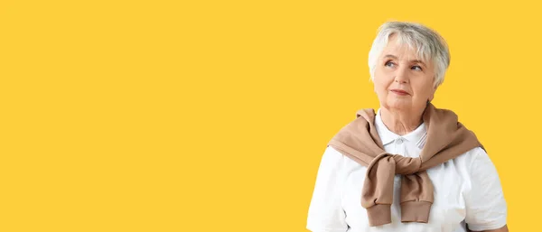 Tänksam Senior Kvinna Gul Bakgrund Med Utrymme För Text — Stockfoto