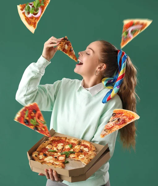 漂亮的年轻女子在绿色背景下吃着美味的披萨 — 图库照片