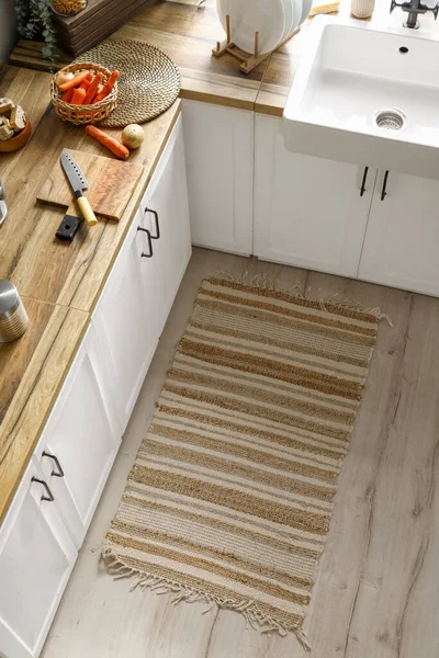 Stylish rug on floor in modern kitchen