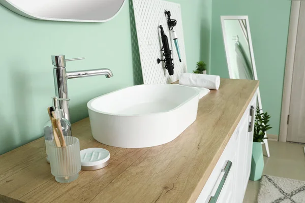 浴室的冲浪板上有水池 牙刷和发式工具的柜台 — 图库照片