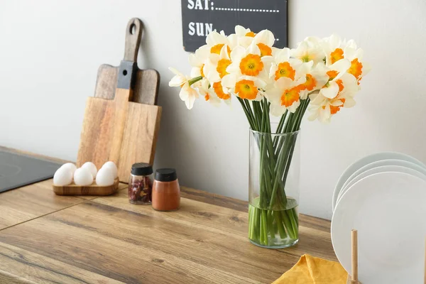 在木制厨房柜台上挂着盛开的水仙花 — 图库照片