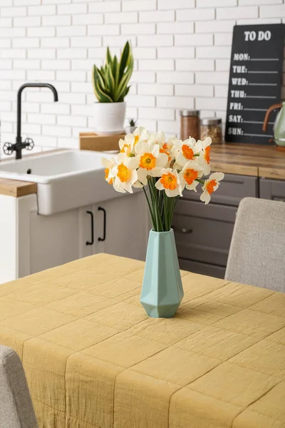 花瓶ともに咲くナルシシズム花でテーブルの上に現代的なキッチン — ストック写真