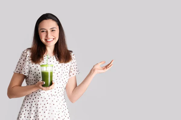 Junge Frau Mit Einem Glas Gemüsesaft Zeigt Etwas Auf Grauem — Stockfoto