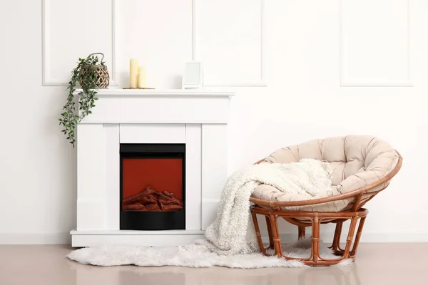 白い壁の近くに毛布と暖炉のある居心地の良いアームチェア — ストック写真