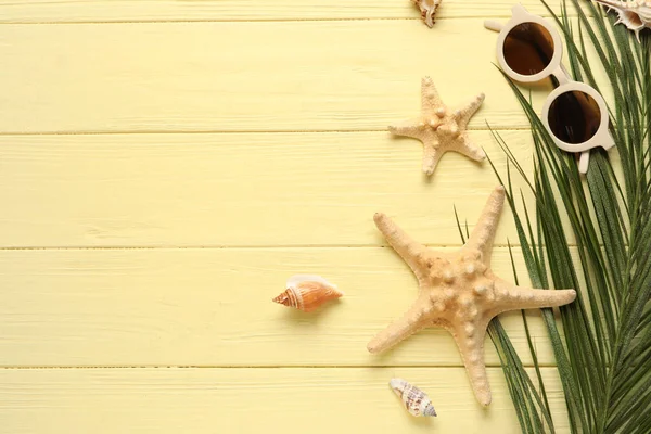 配上时髦的太阳镜 棕榈叶 海星和彩色木制背景的贝壳 — 图库照片