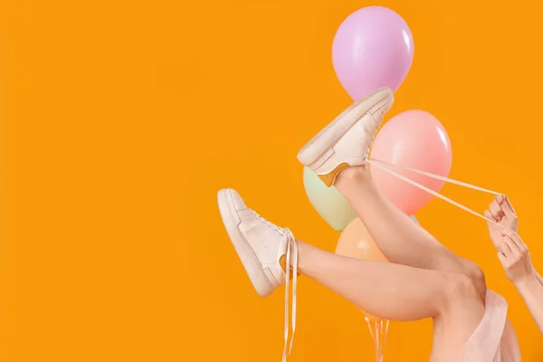 Mujer Joven Atando Cordones Zapatos Con Globos Sobre Fondo Amarillo — Foto de Stock