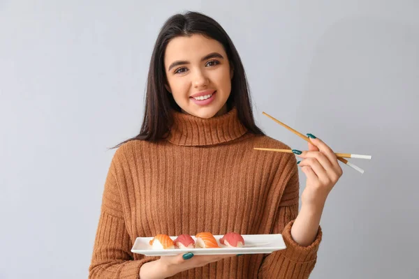 Junge Frau Mit Sushi Auf Hellem Hintergrund — Stockfoto