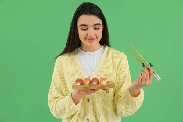 Mujer Joven Feliz Con Sushi Palillos Sobre Fondo Verde — Foto de Stock