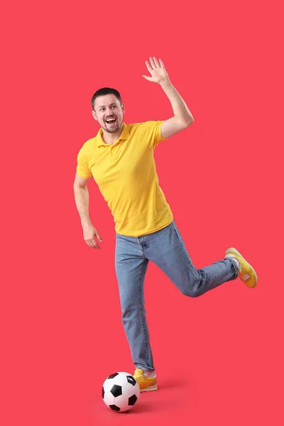 赤い背景でサッカーをしながら手を振って男 — ストック写真