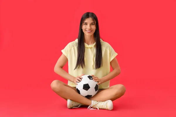 红底足球的年轻女子 — 图库照片