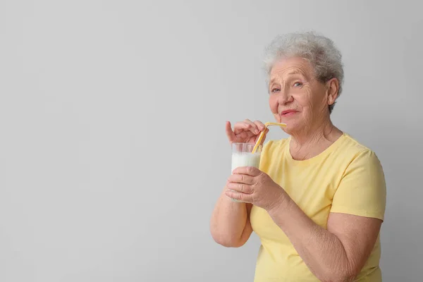 Seniorin Mit Glas Milch Auf Grauem Hintergrund — Stockfoto