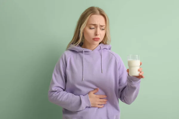 Αναστατωμένη Νεαρή Γυναίκα Ένα Ποτήρι Γάλα Πράσινο Φόντο — Φωτογραφία Αρχείου