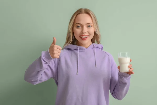 Молода Жінка Склянкою Молока Показує Великий Палець Зеленому Фоні — стокове фото