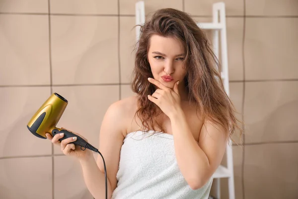 Banyoda Saç Kurutma Makinesi Olan Düşünceli Genç Bir Kadın — Stok fotoğraf