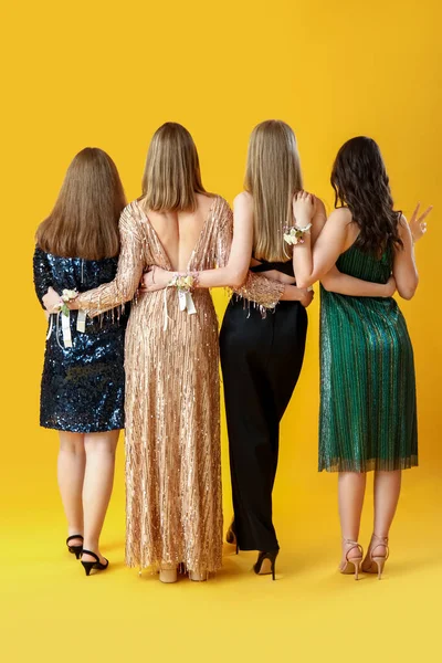 Jonge Vrouwen Gekleed Voor Het Bal Gele Achtergrond Achteraanzicht — Stockfoto