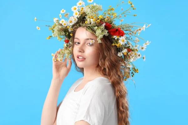 青の背景に花の花輪の美しい若い女性 — ストック写真