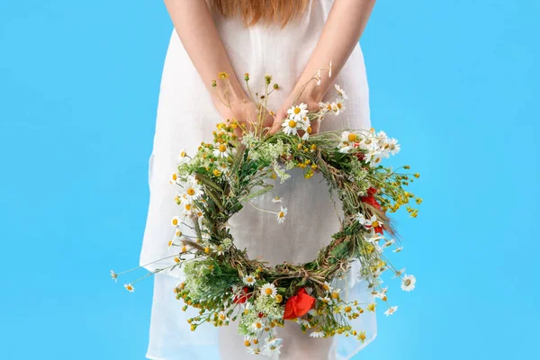 stock image Beautiful young woman with flower wreath on blue background, back view. Summer solstice