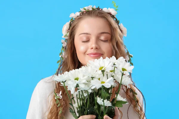 Mavi Arka Planda Çiçek Demeti Olan Güzel Genç Bir Kadın — Stok fotoğraf