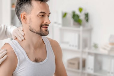 Cildiyeciler klinikteki genç adamı yakından inceliyor.