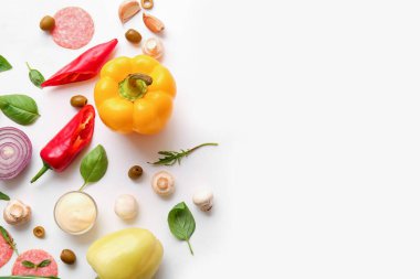 Beyaz arkaplanda pizza hazırlamak için gerekli malzemeler