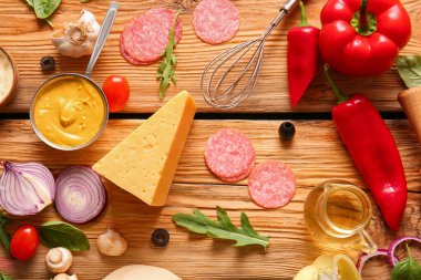 Tahta arka planda pizza hazırlamak için gerekli malzemeler