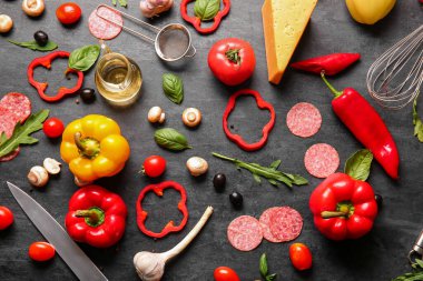 Siyah arkaplanda pizza hazırlamak için gerekli malzemeler