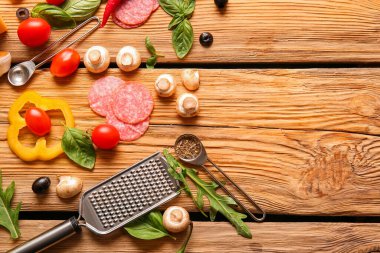 Tahta arka planda pizza hazırlamak için gerekli malzemeler